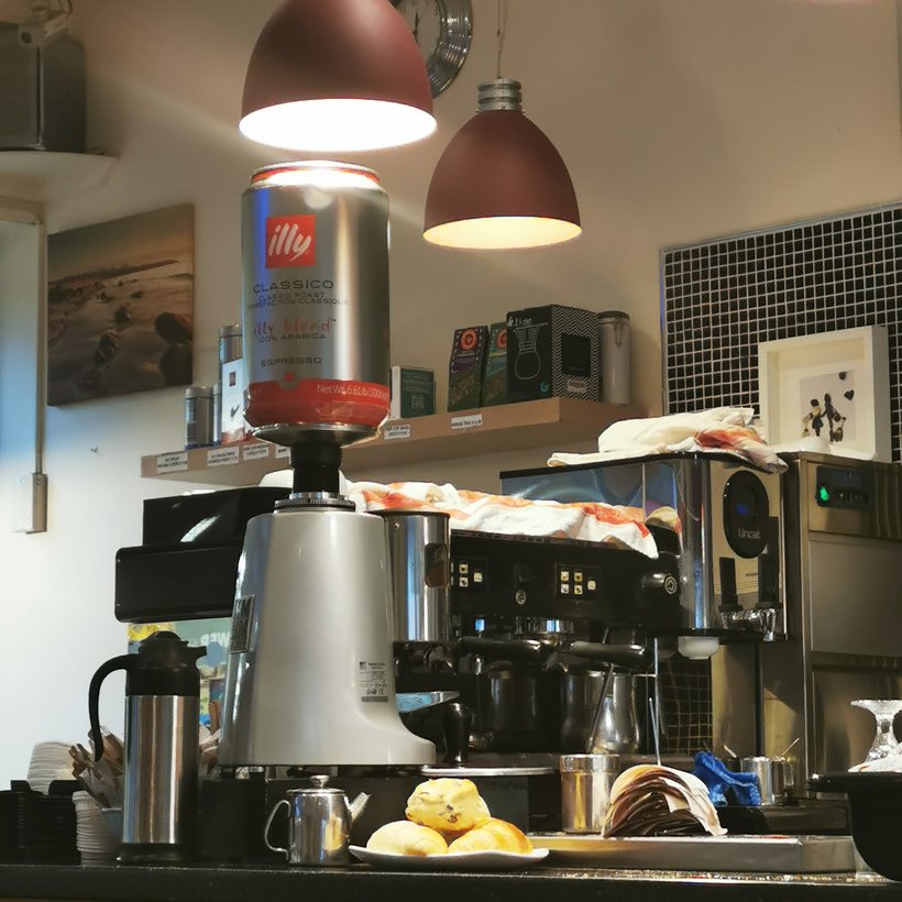 The espresso machine behind the counter at Cates Café, with an illy coffee canister on top.