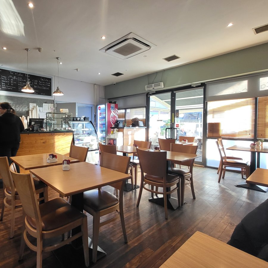Wooden tables and chairs by the window at Cates Café.